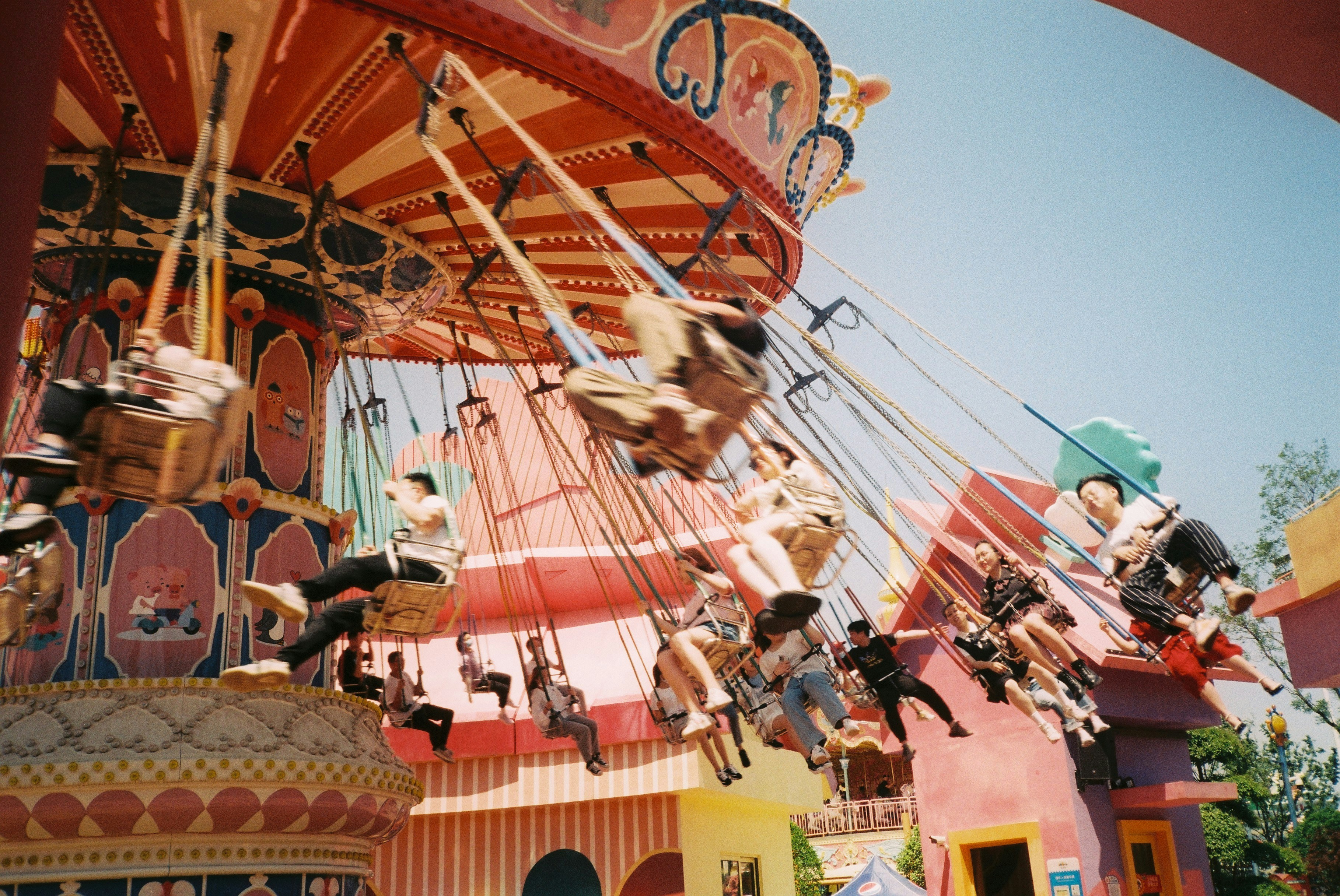 People enjoying a spinning swing ride at an amusement park