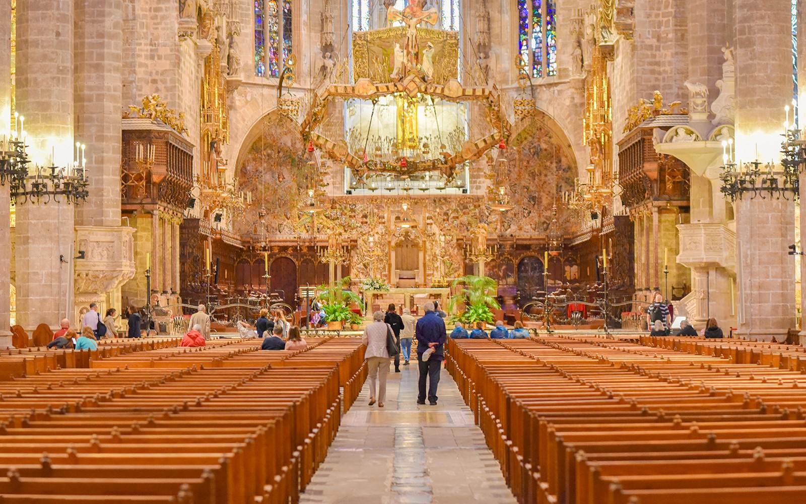 Interior de la Catedral de Palma con un altar ornamentado y vitrales.
