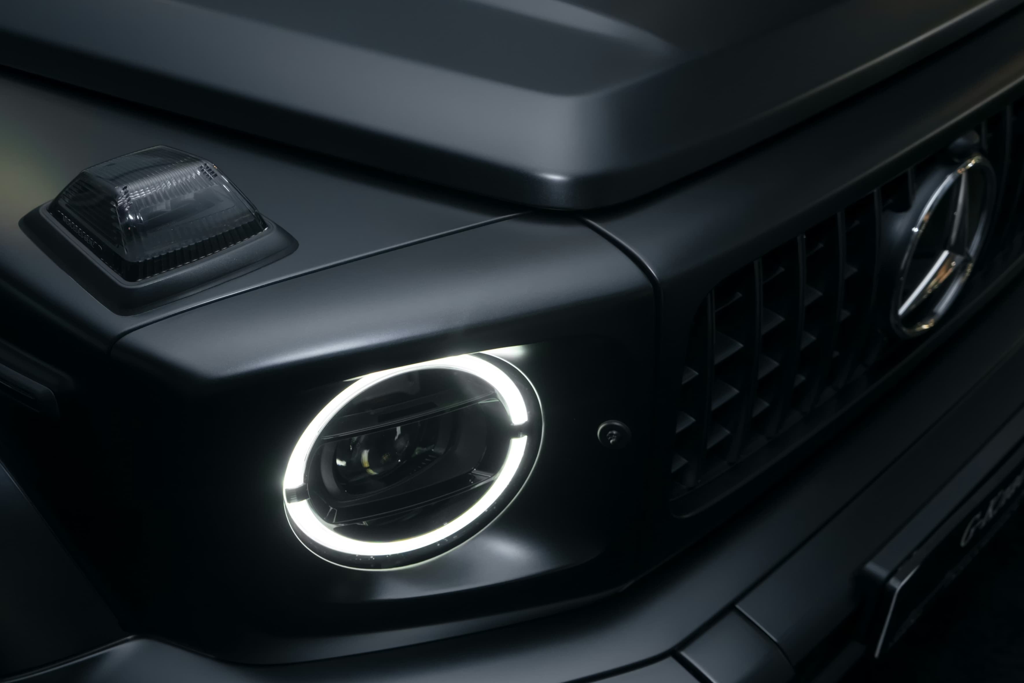 Face avant d’un Mercedes Classe G noir mat dans un univers premium