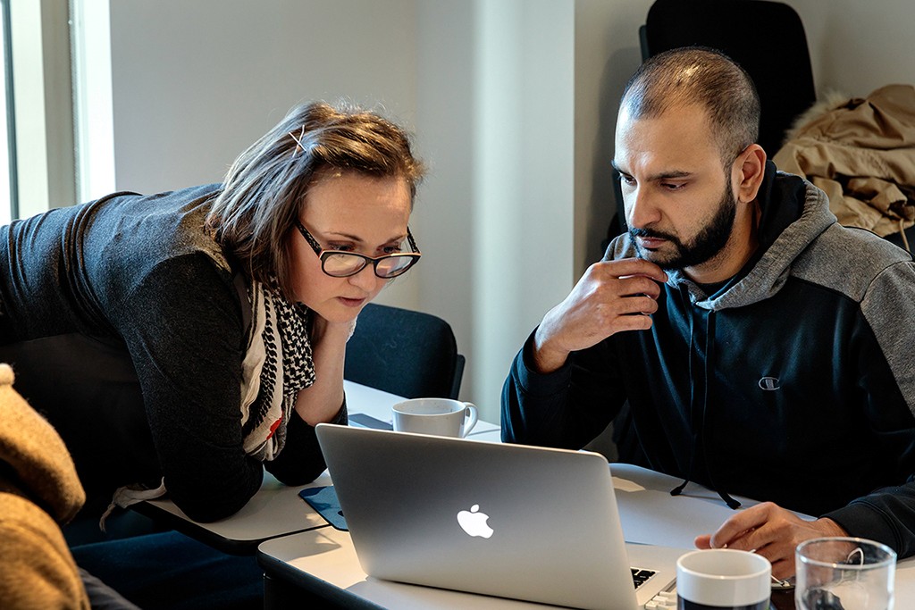 A practitioner analyzing a wall of data and themes, making sense of the problem space.