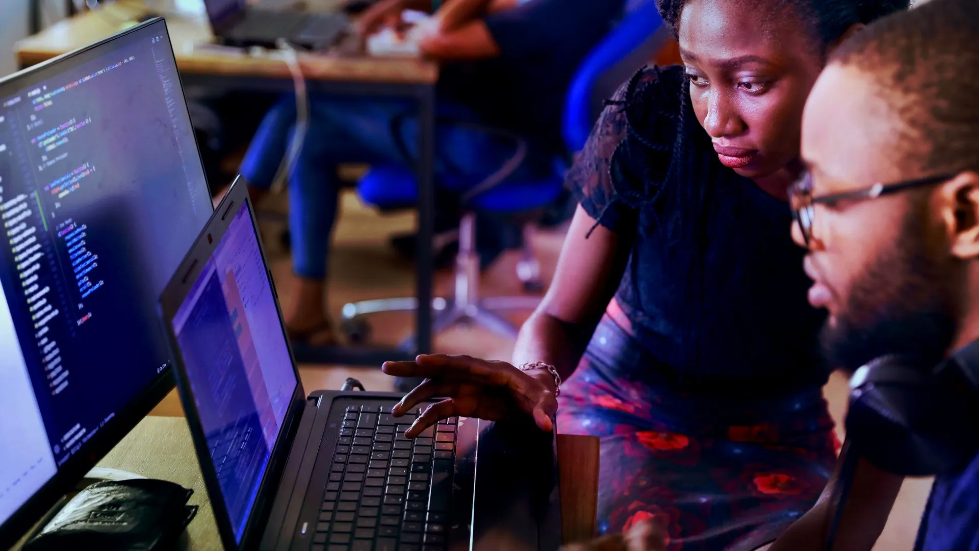 Two people work together at a laptop
