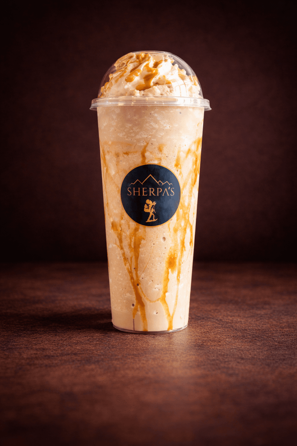 Blended Frappe with caramel drizzle and creamy foam in a Café Sherpa's cup, Brookfield WI. Customizable smooth blended coffee with your favorite flavors.