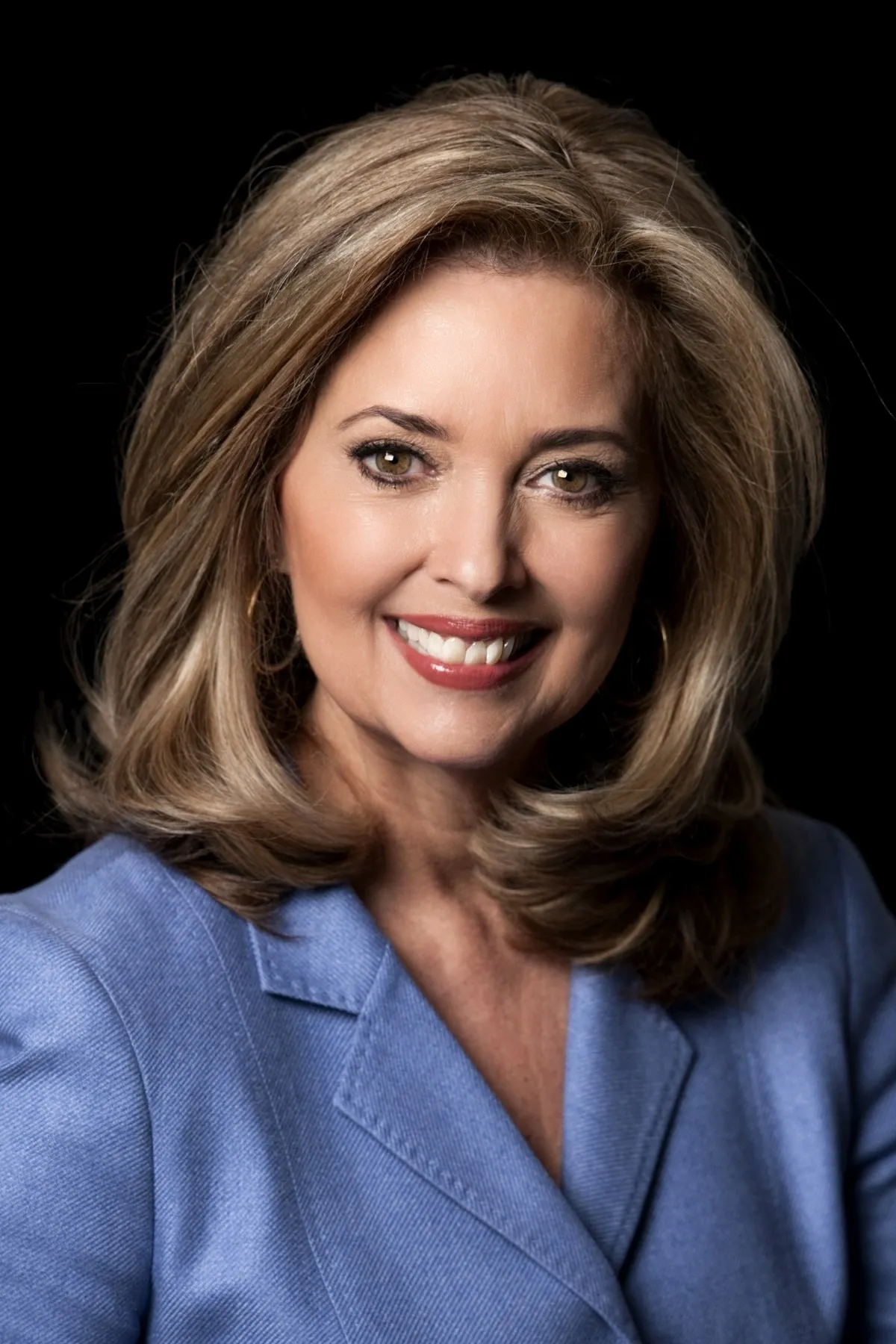 Portrait of Pamela Martin, a distinguished journalist and news broadcaster, with a warm, professional smile and poised demeanor