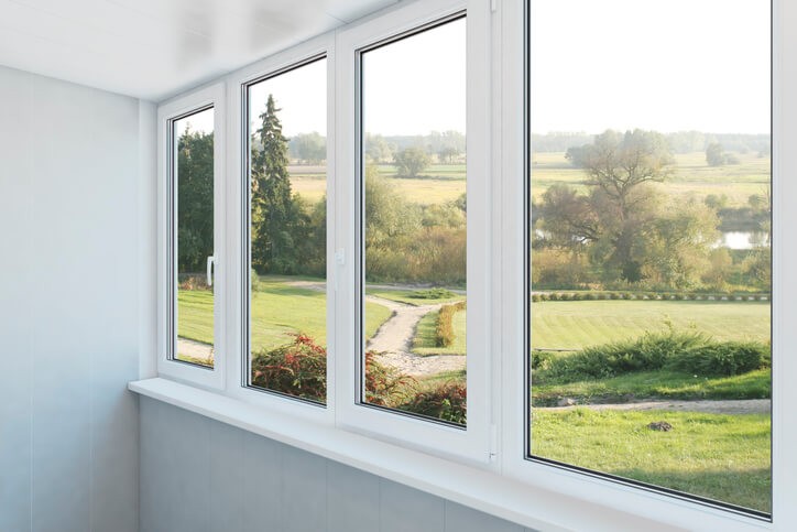 windows without motorized blinds overlooking green fields