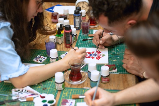 Participants immersed in a Turkish tile painting workshop in Istanbul, surrounded by ceramic art supplies. This hands-on experience is one of the top Istanbul attractions for those interested in Turkish tile art and ceramic workshops.