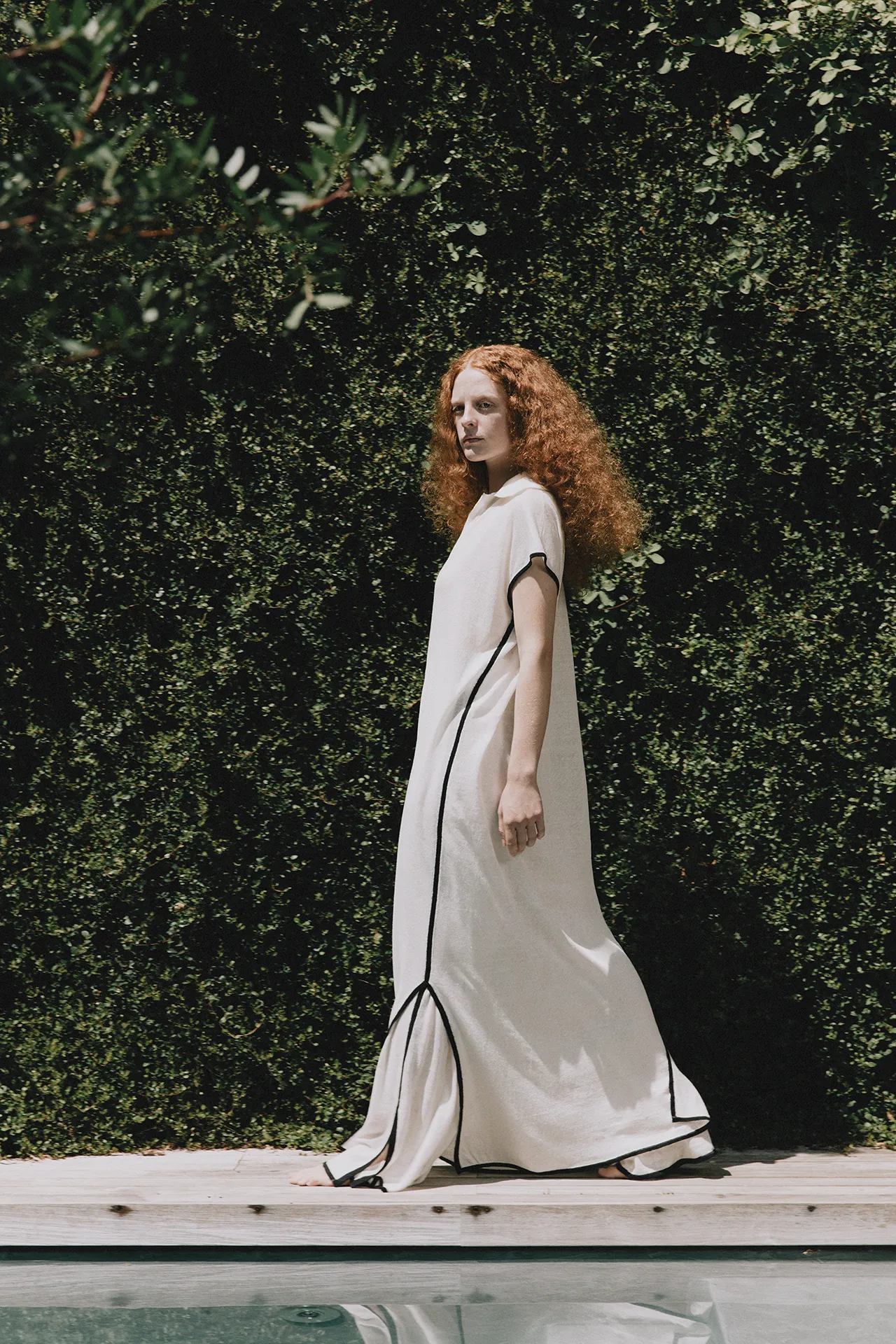 Annapurna SS26 collection white sleeveless maxi knit dress with contrasting black piping and side slits.