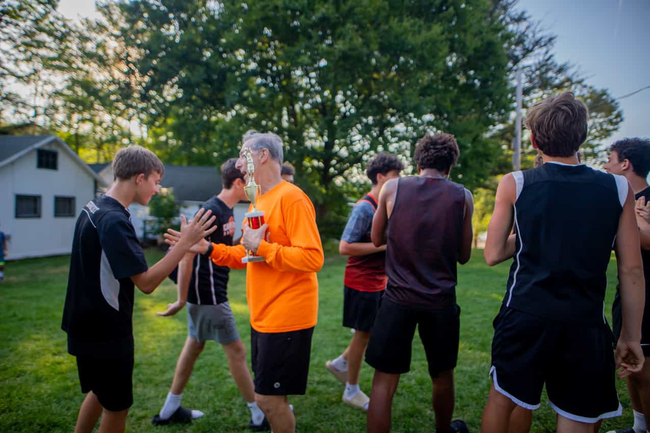 Rich Moss handing a trophy to campers after a game