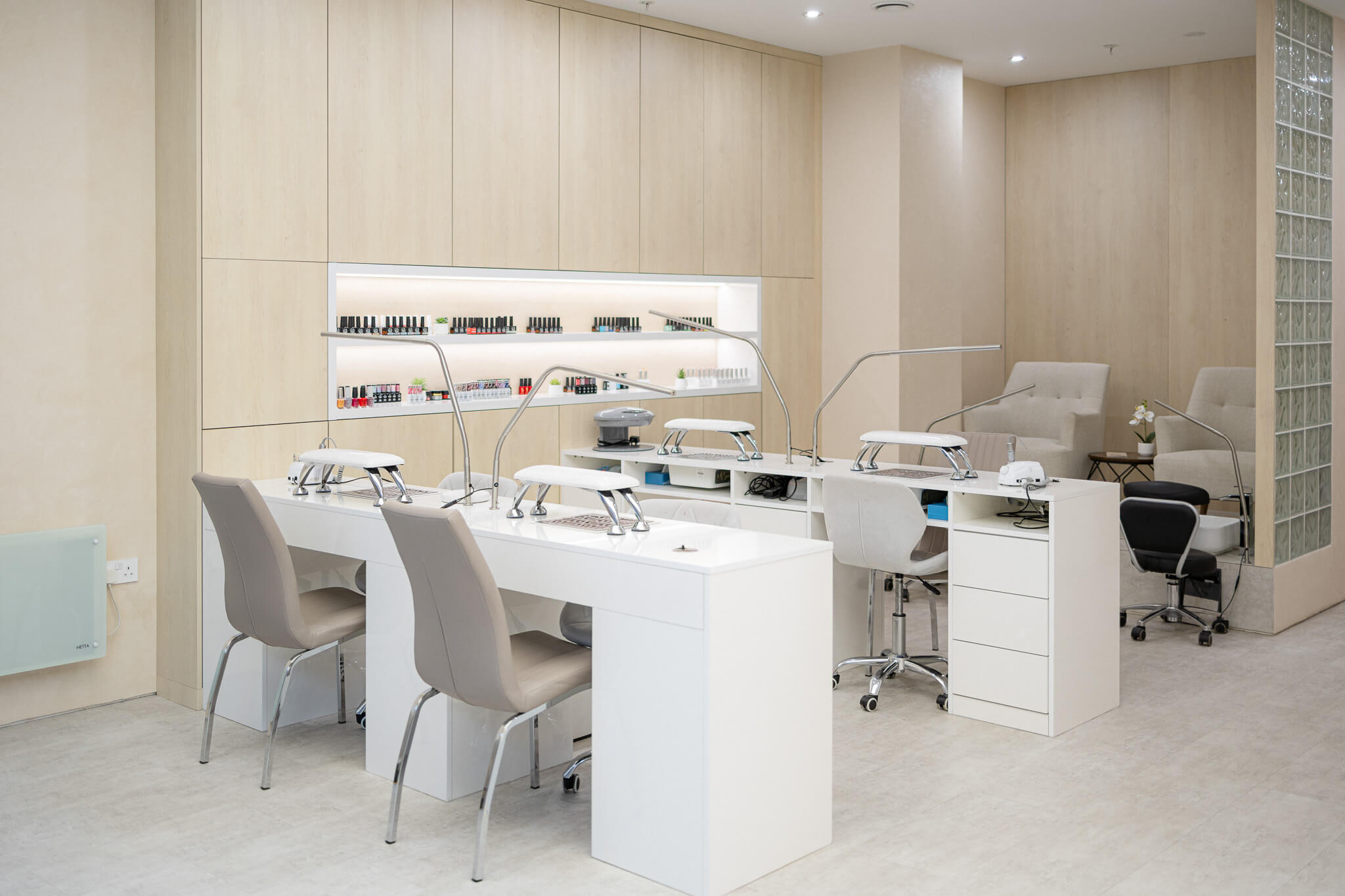 Modern nail and beauty salon interior with minimalist design and manicure stations.