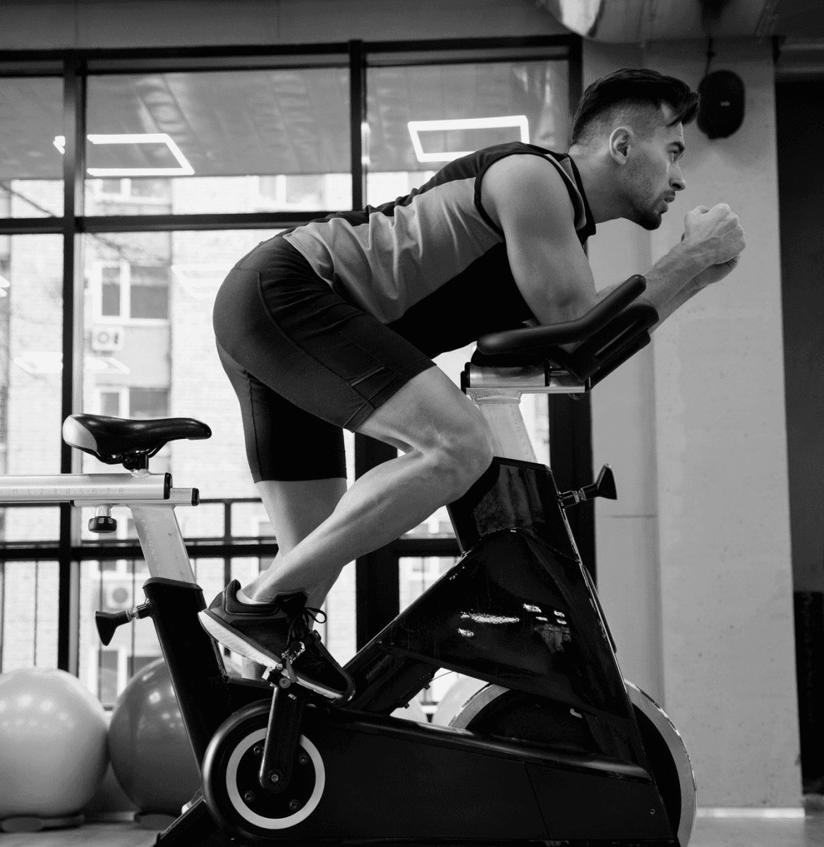 Strong man improving fitness through cycling class