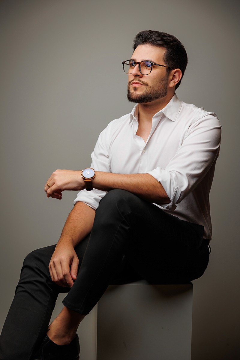 kainan de oculos sentado