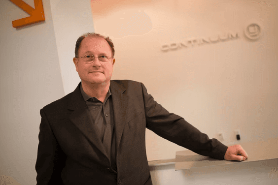 Gianfranco standing in front of a Continuum logo