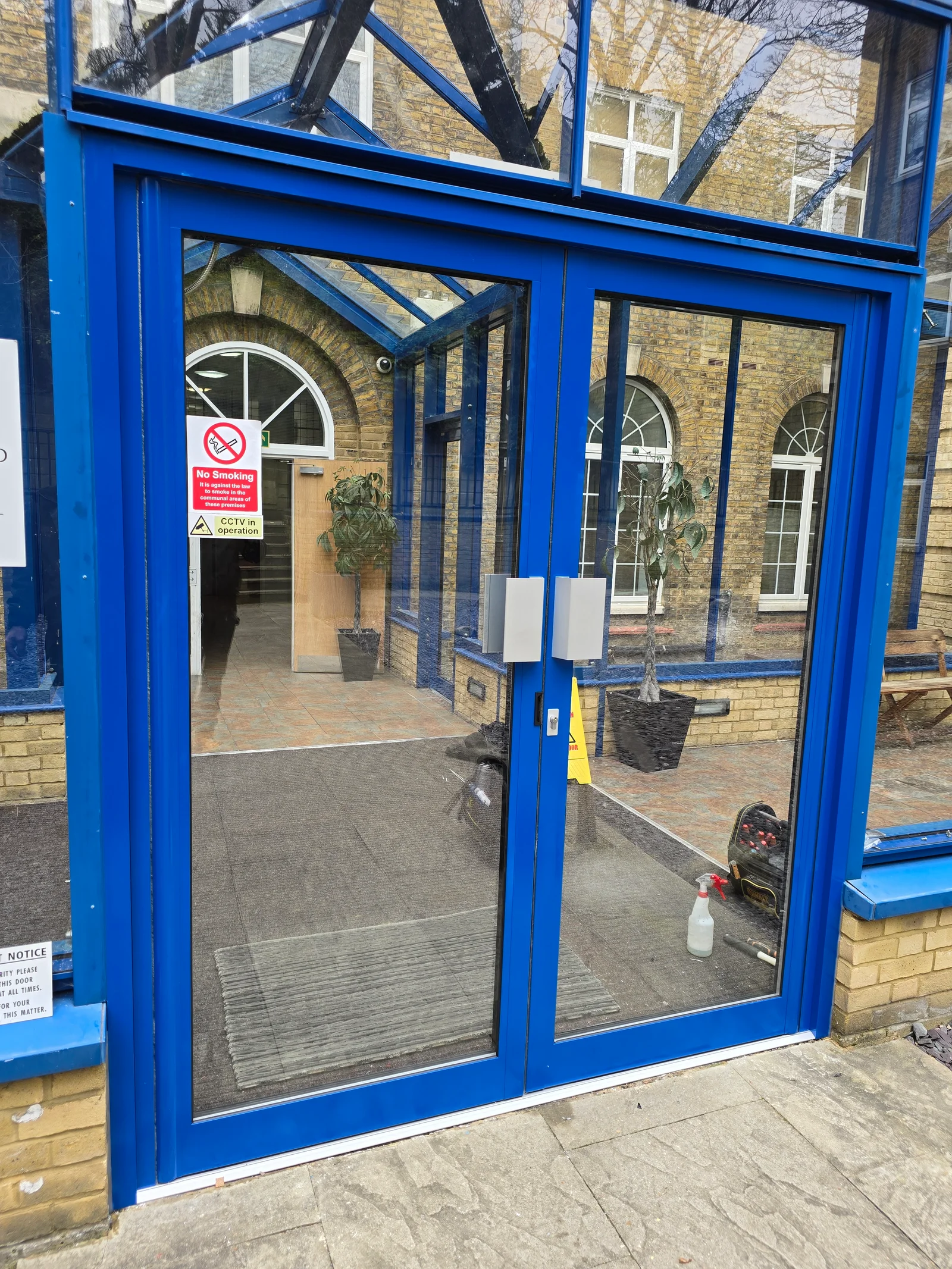 A glazed aluminium communal entrance door fitted by GXG Aluminium