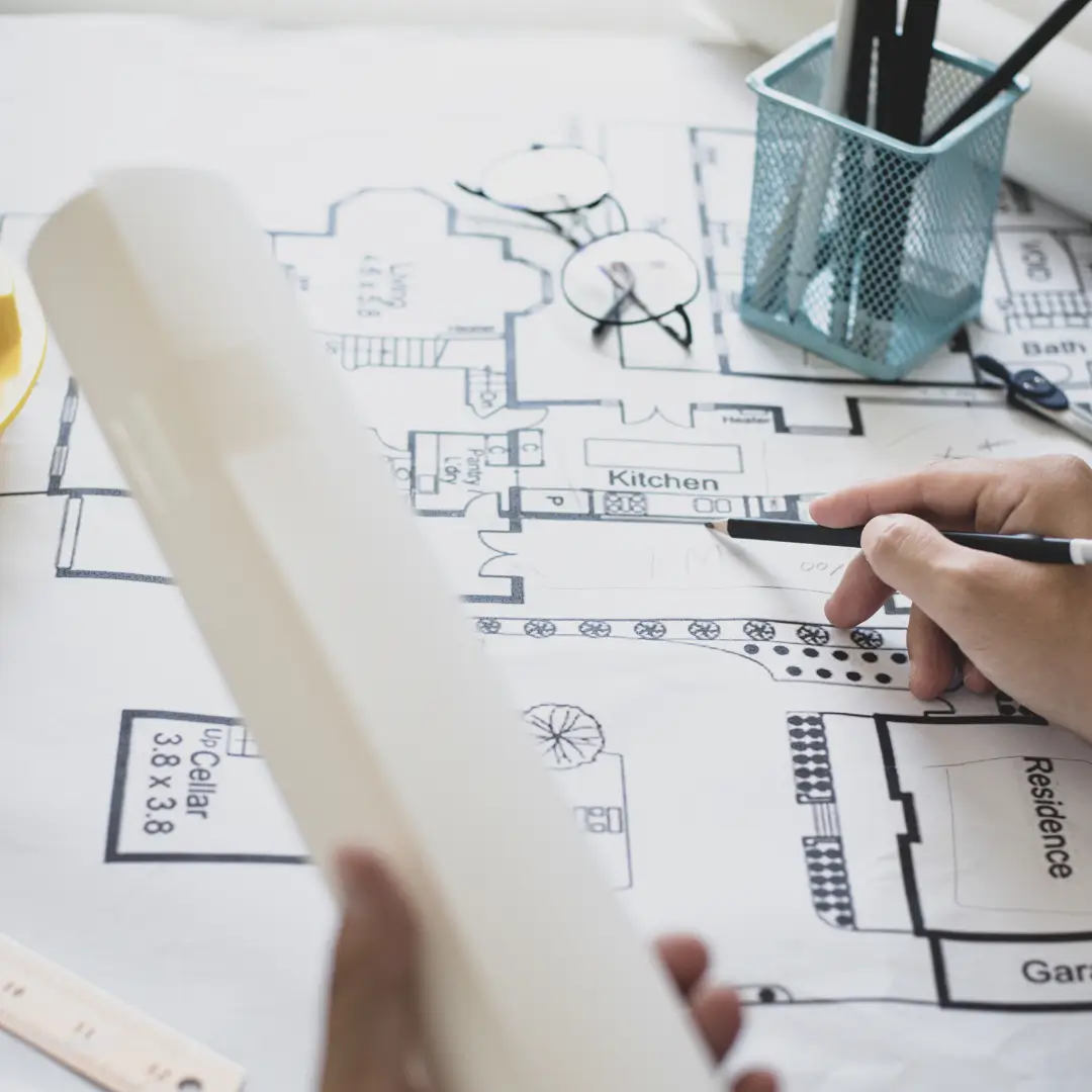 A hand with a pencil sketching a new home design