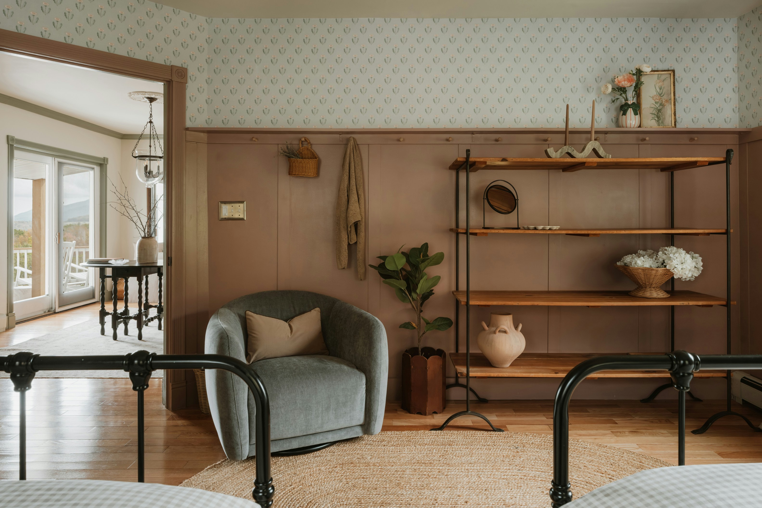 Cozy bedroom with armchair, shelving, and beds.