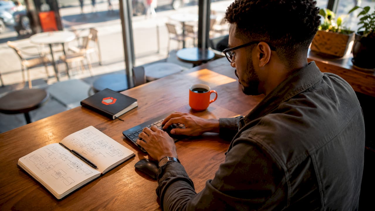 Hands typing onboarding flow notes at laptop
