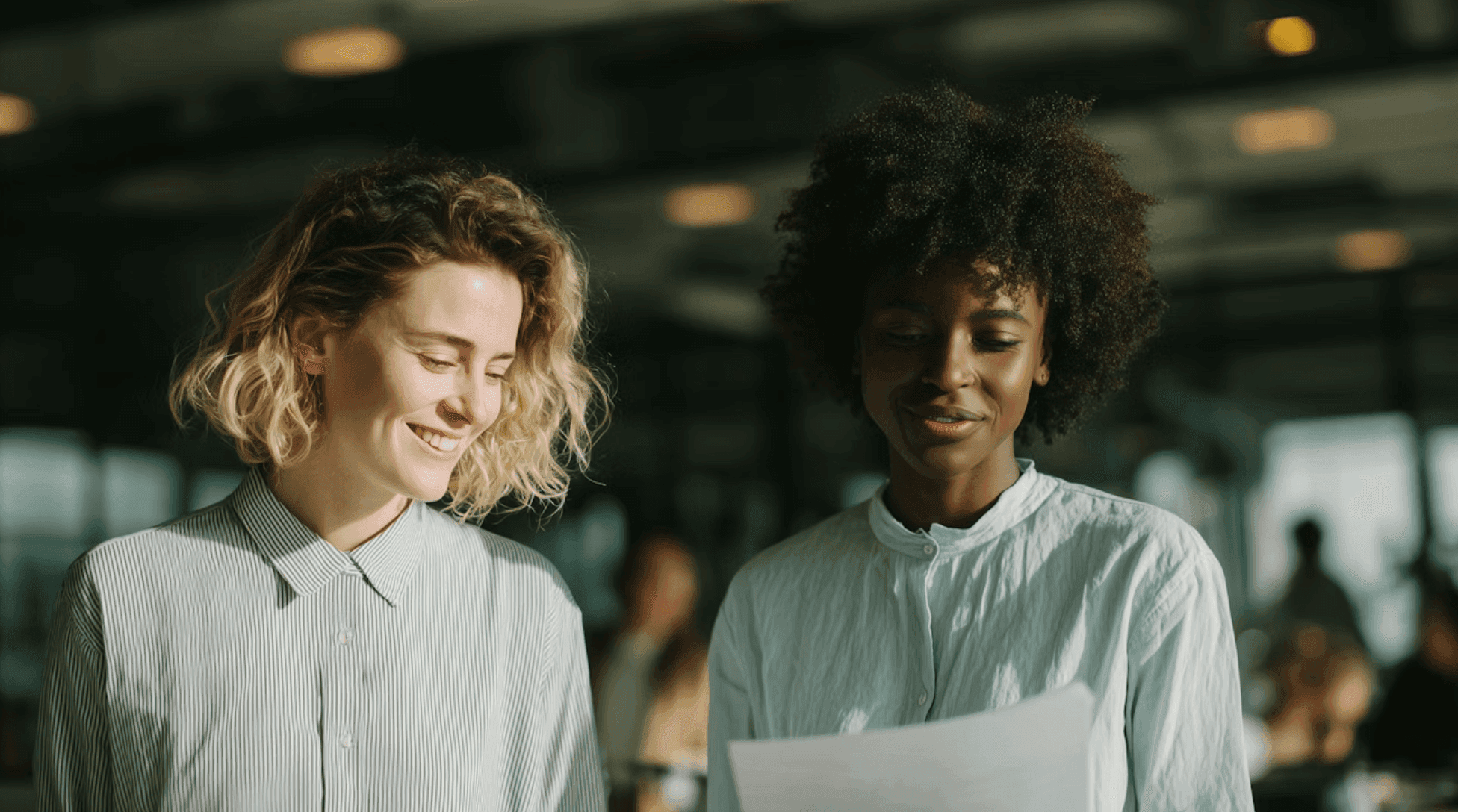 Two women smiling and talking in a casual office setting