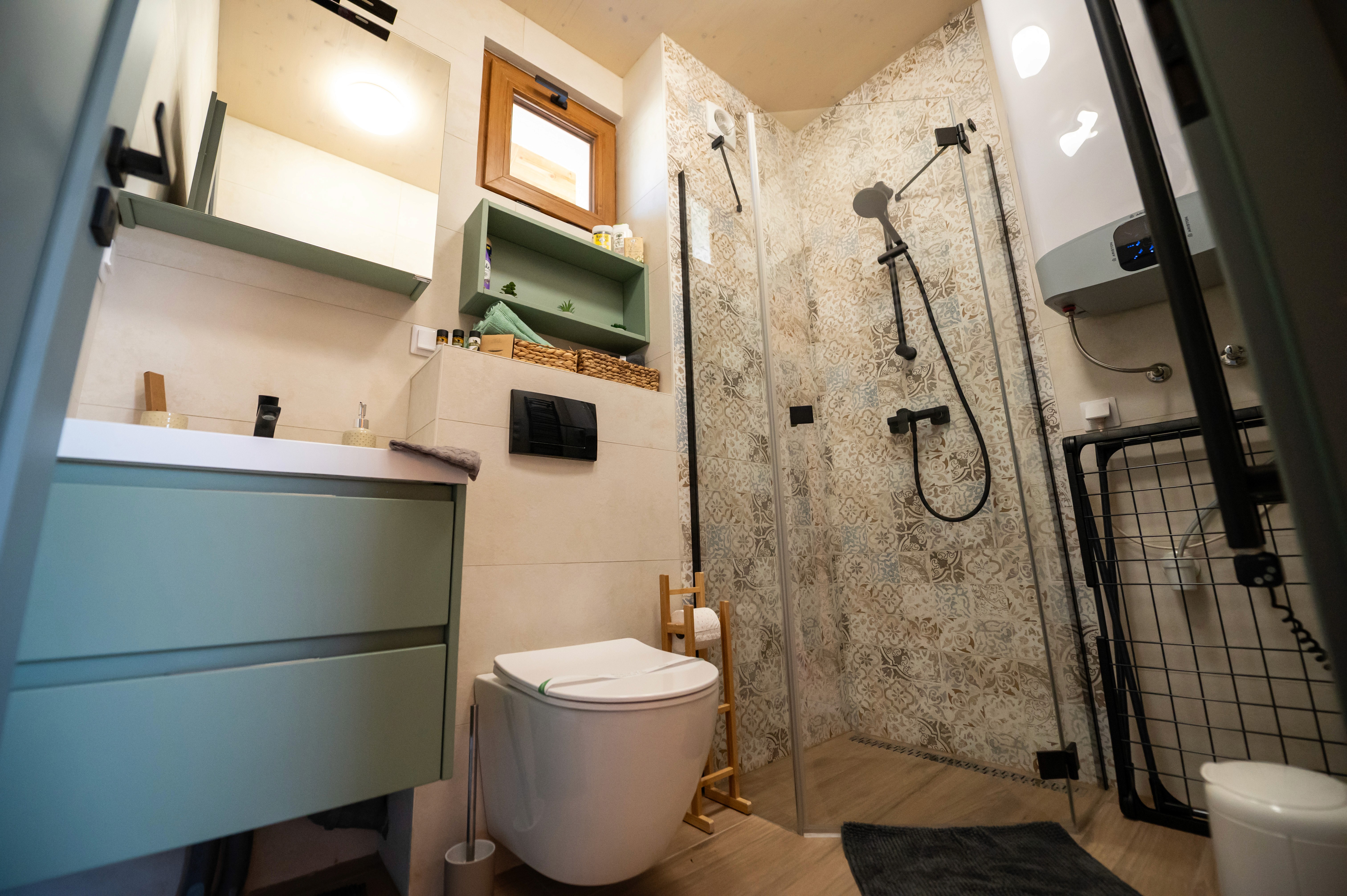 Fürdőszoba széleslátójú fotója, sarokzuhannyal és modern wc kagylóval.