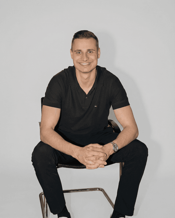 Portrait of a person in a pink sweater against a light background