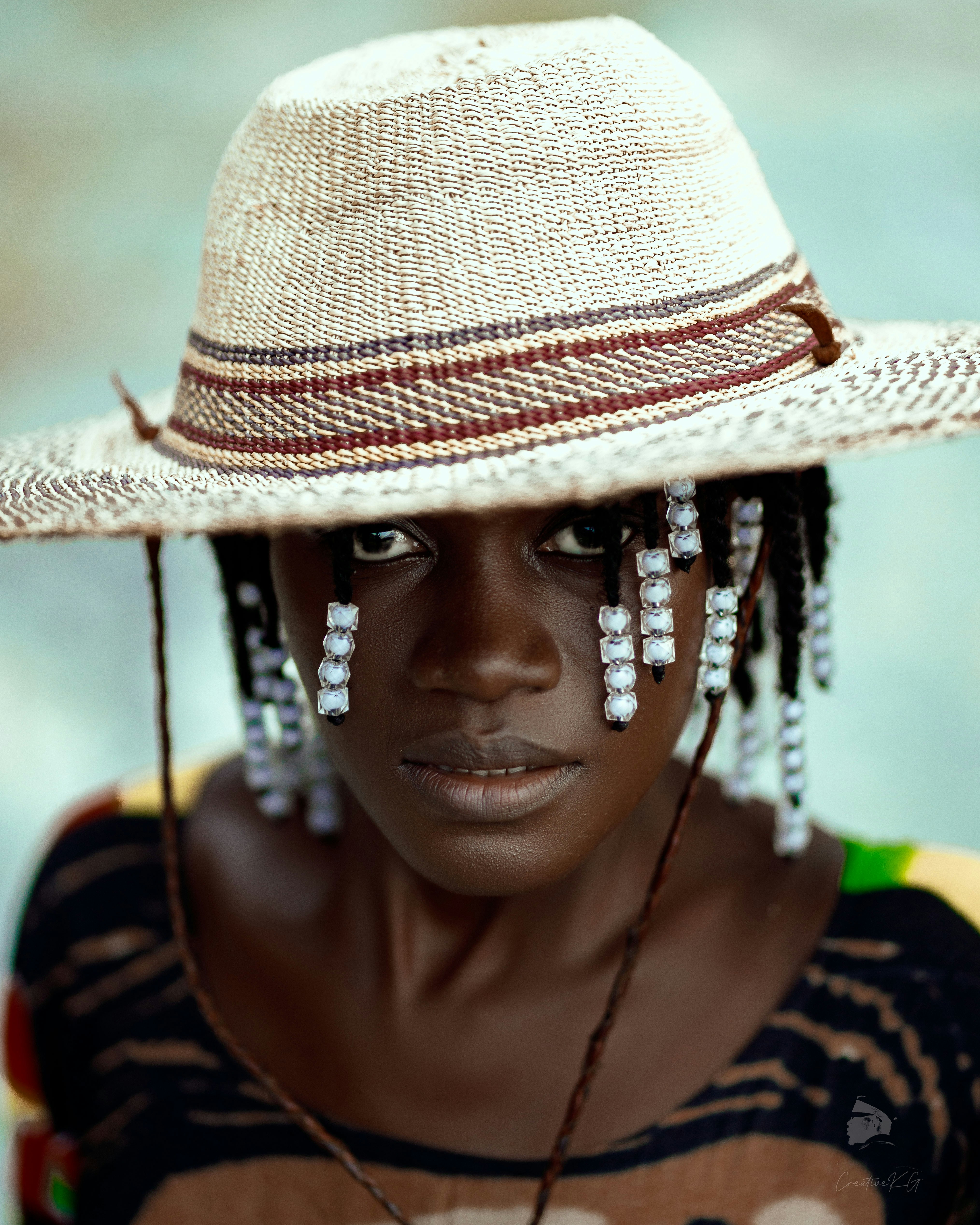 a woman wearing a straw hat with beads