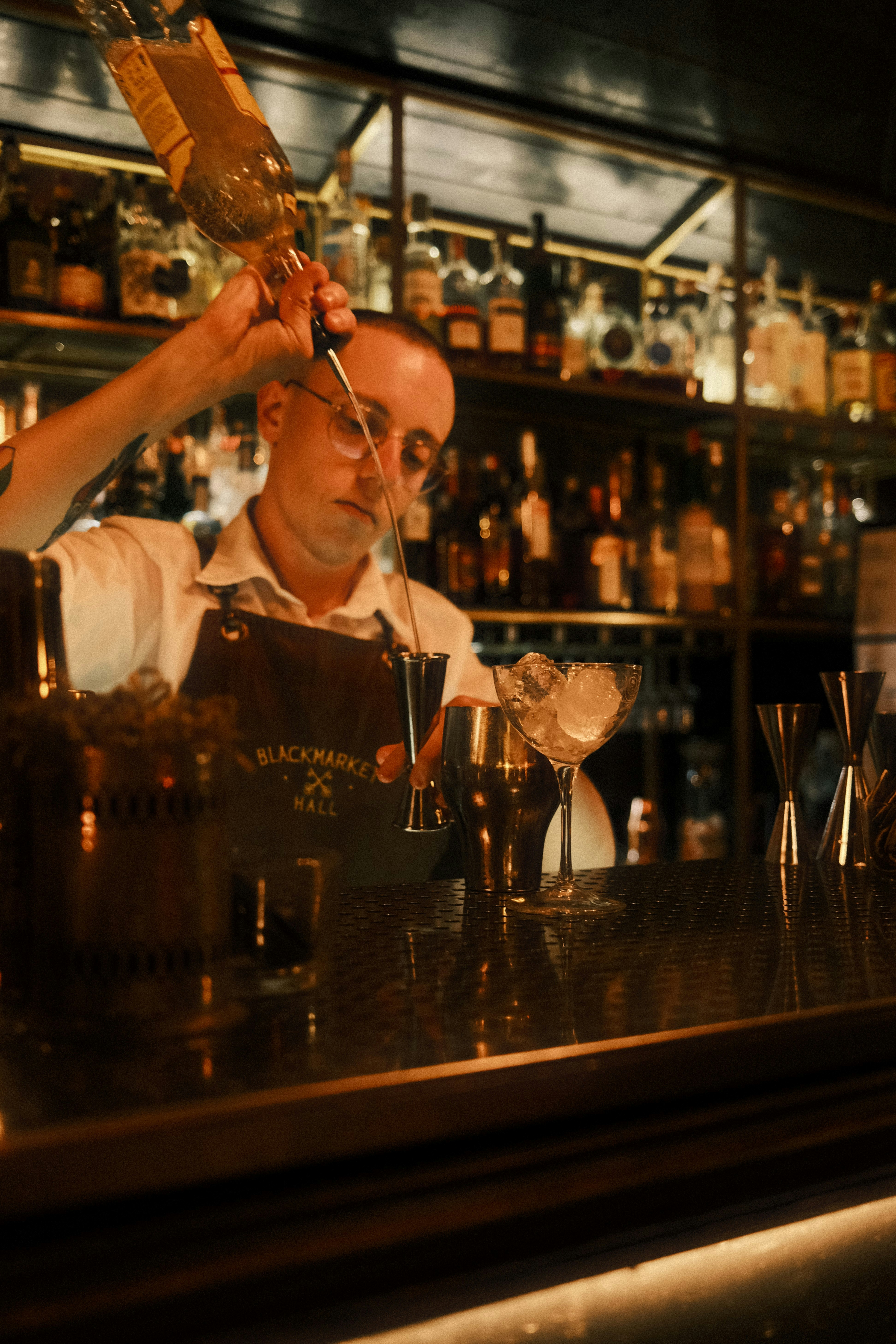 A bartender is making a drink at a bar