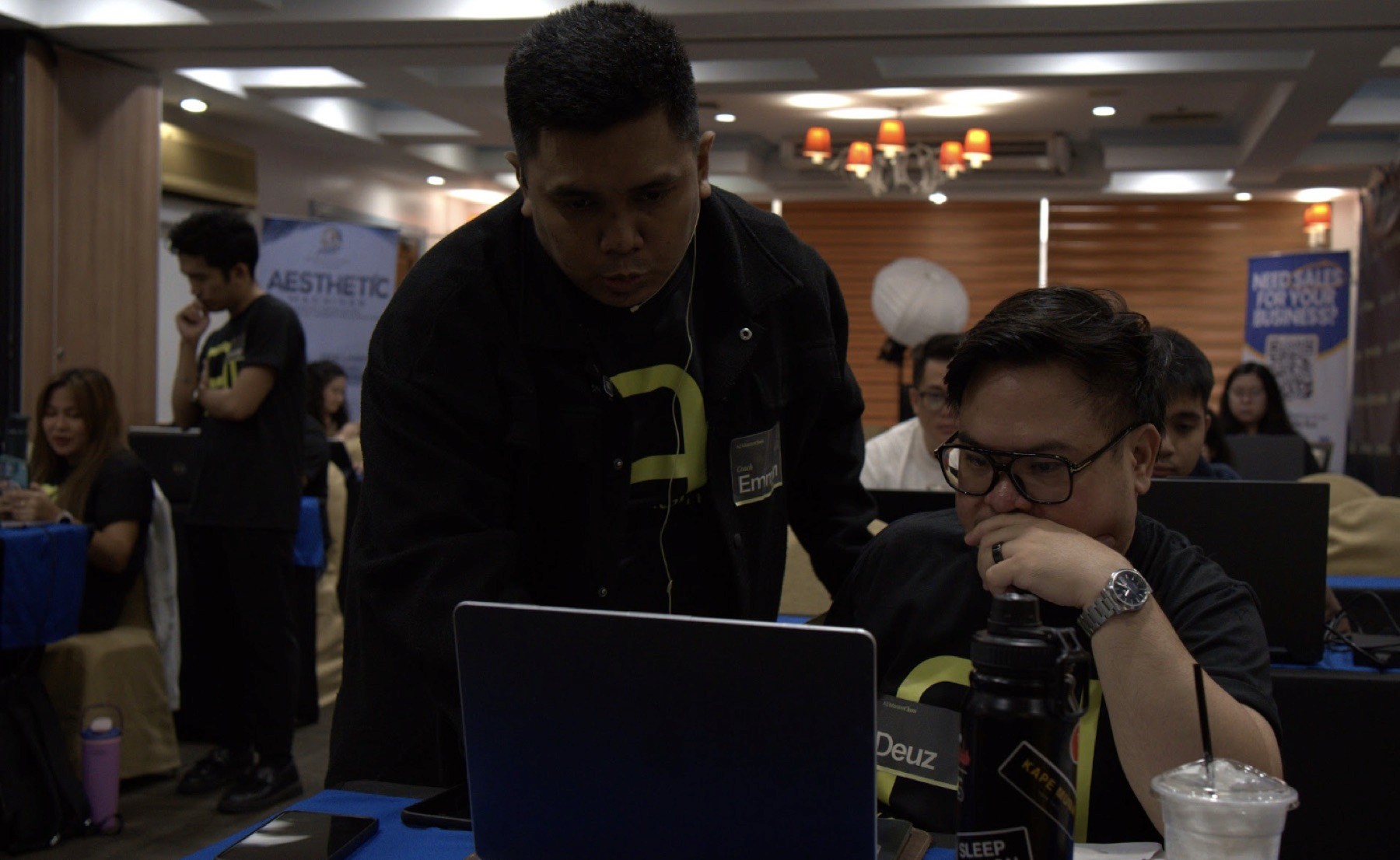 Coach Emman helping a participant build at his laptop