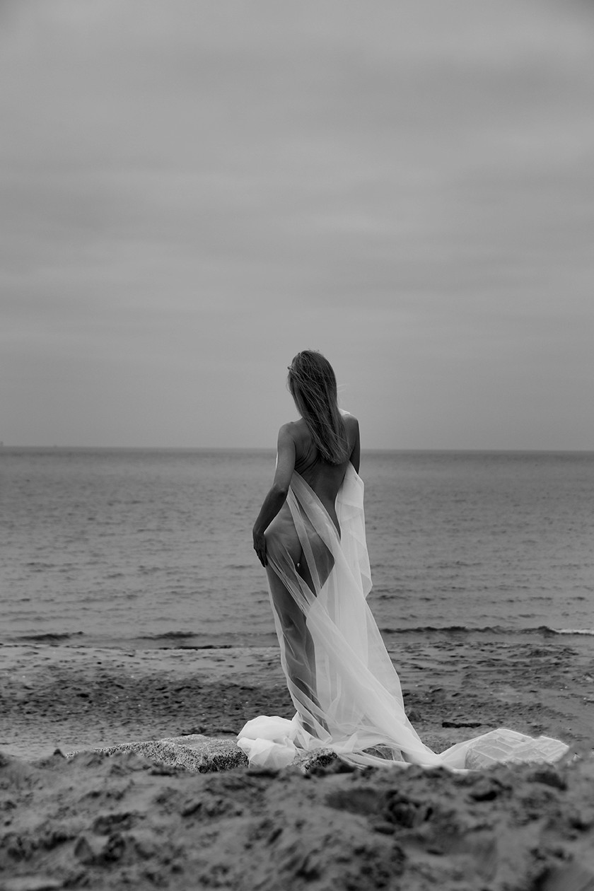 Woman's back facing the sea, white tulle, Gdansk - Stone and Skin - Agnieszka Czyzkowska Photography