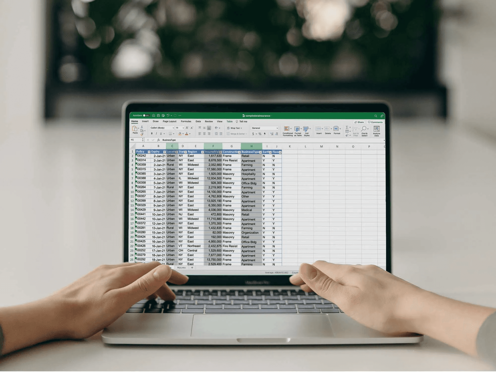 Person typing on laptop with spreadsheet - How to Categorize Expenses in Excel
