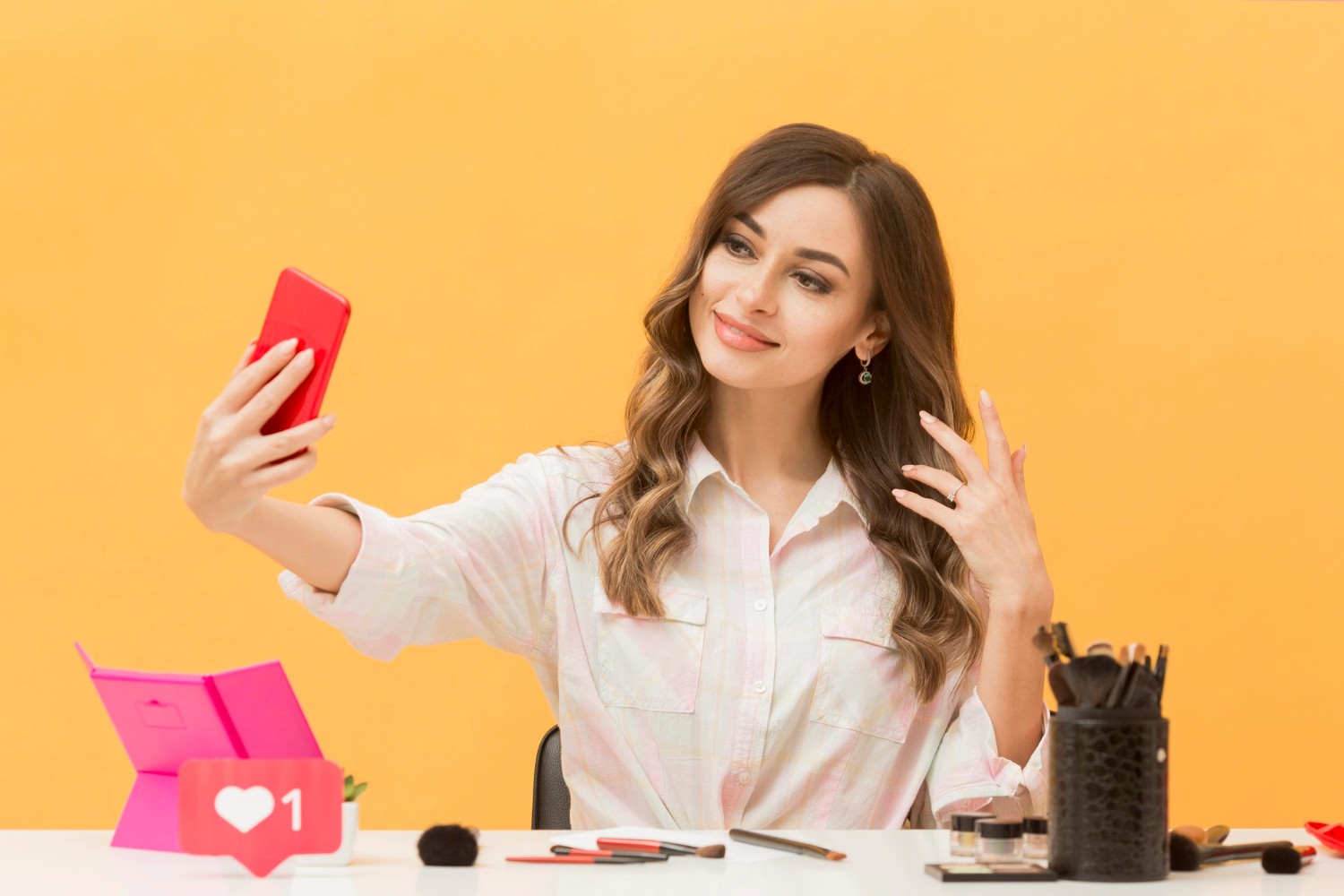 A woman smiles as she takes a selfie with her smartphone, capturing a moment of joy and self-expression.