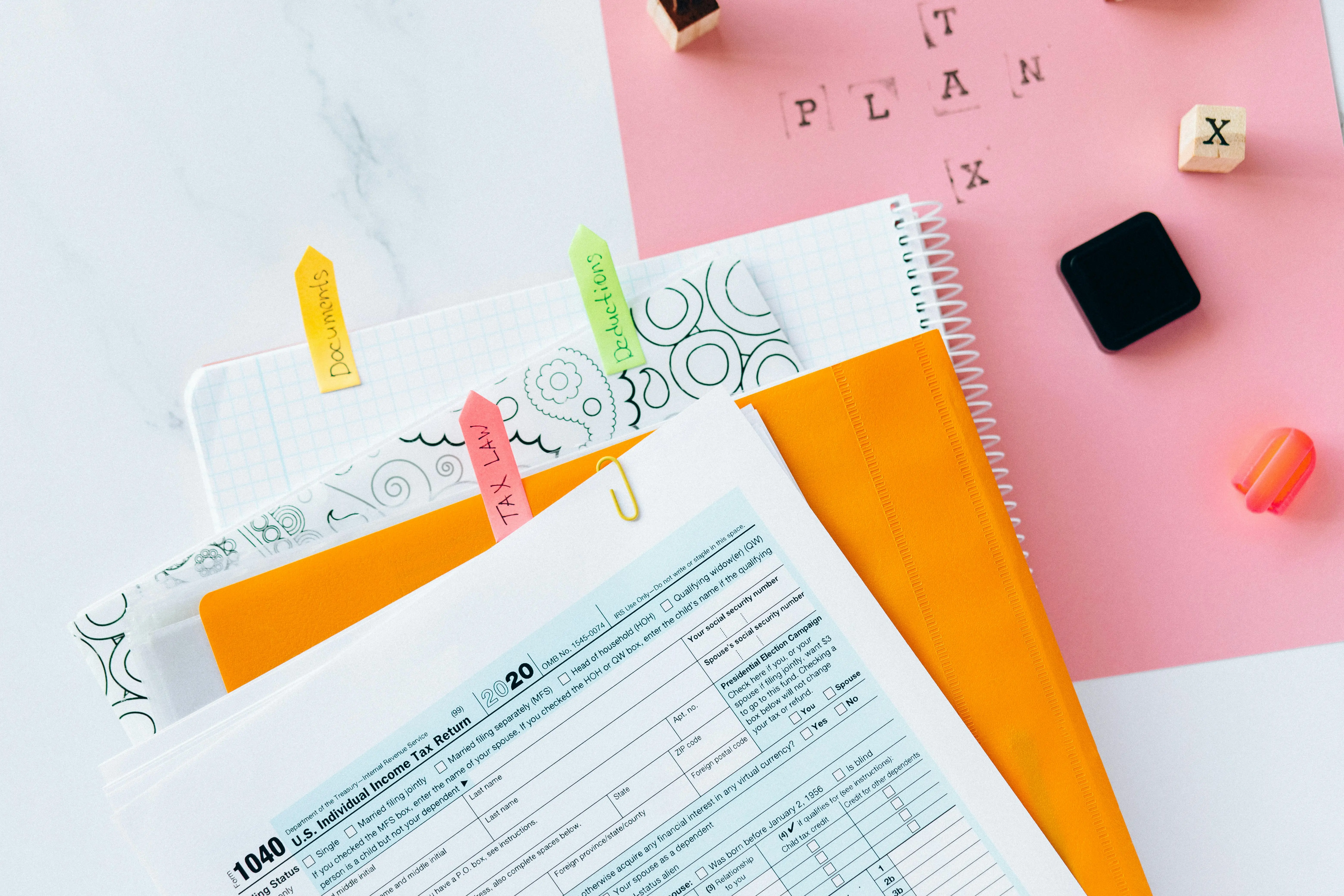 Organized tax documents and folders labeled with notes for deductions and tax law