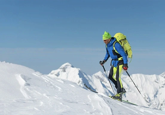 Homme monte une montagne avec skis de randonnée