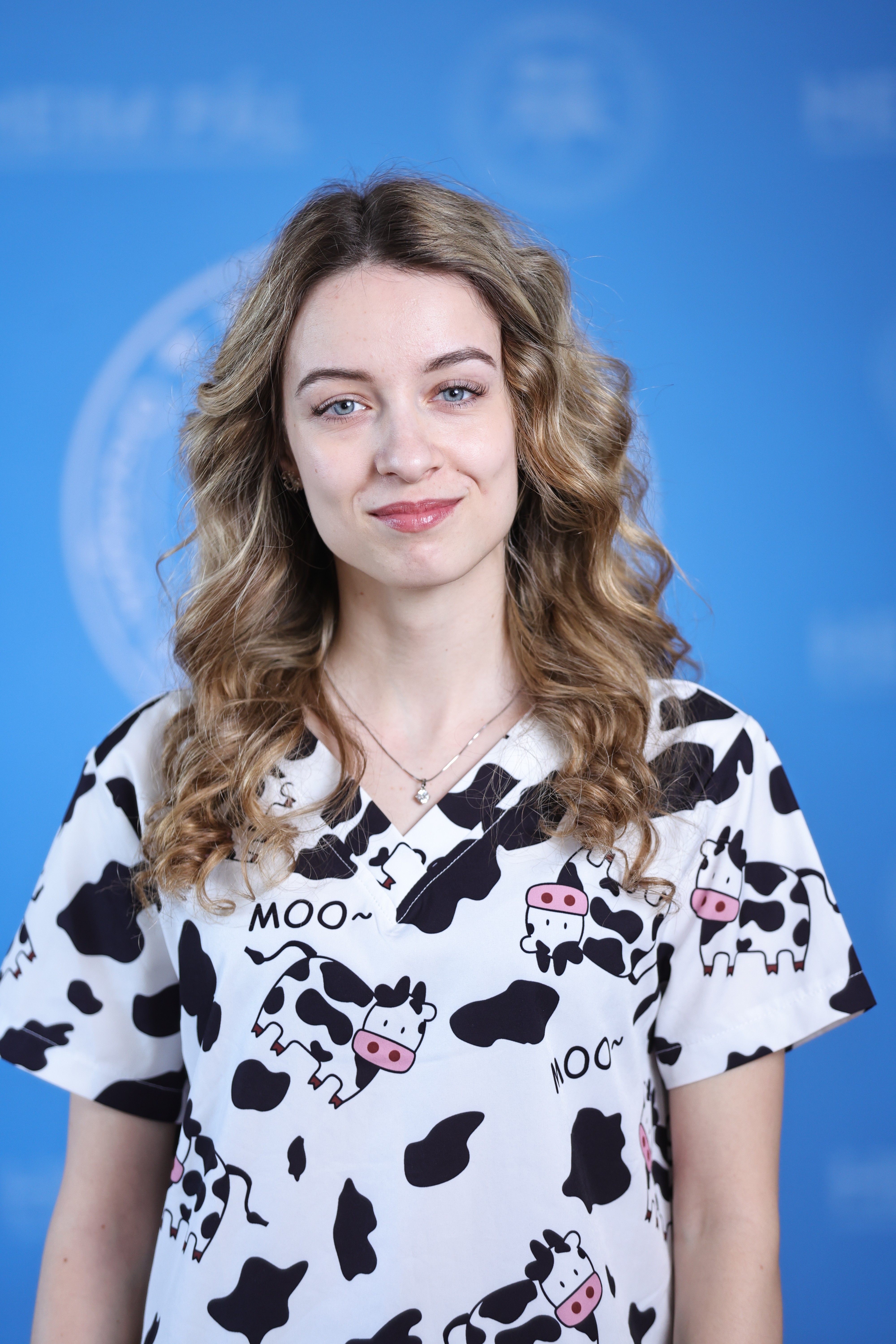 Hosszúhajú szőke nő tehénmintás orvosi ruházatban