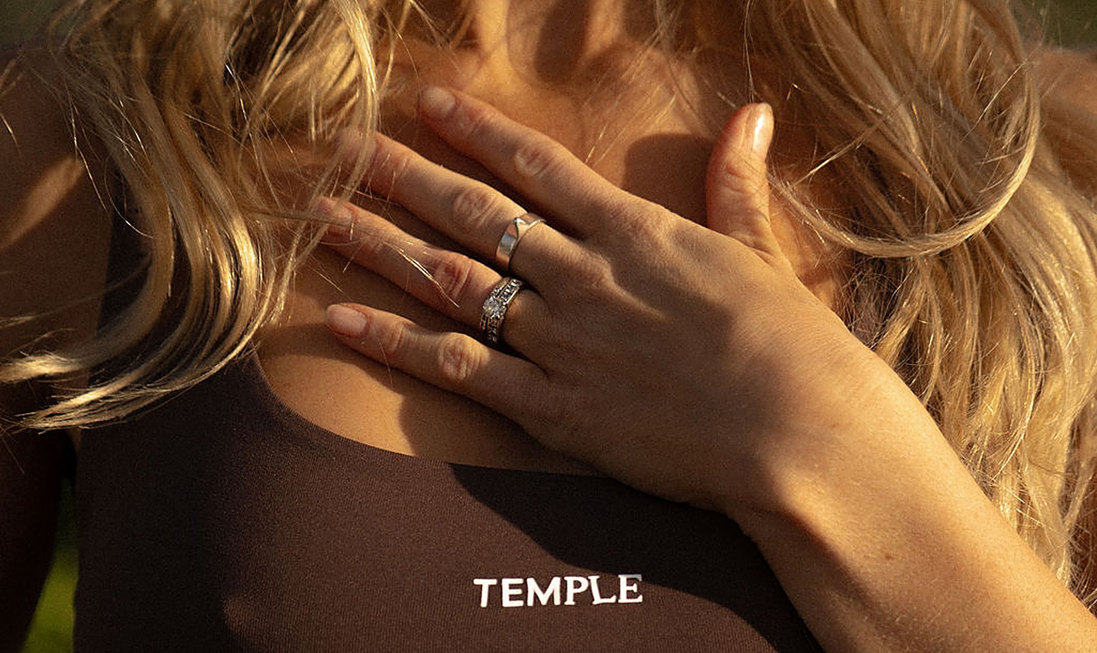 Woman resting a hand on her chest in warm light, listening to what the body is saying about low libido in women | My Temple