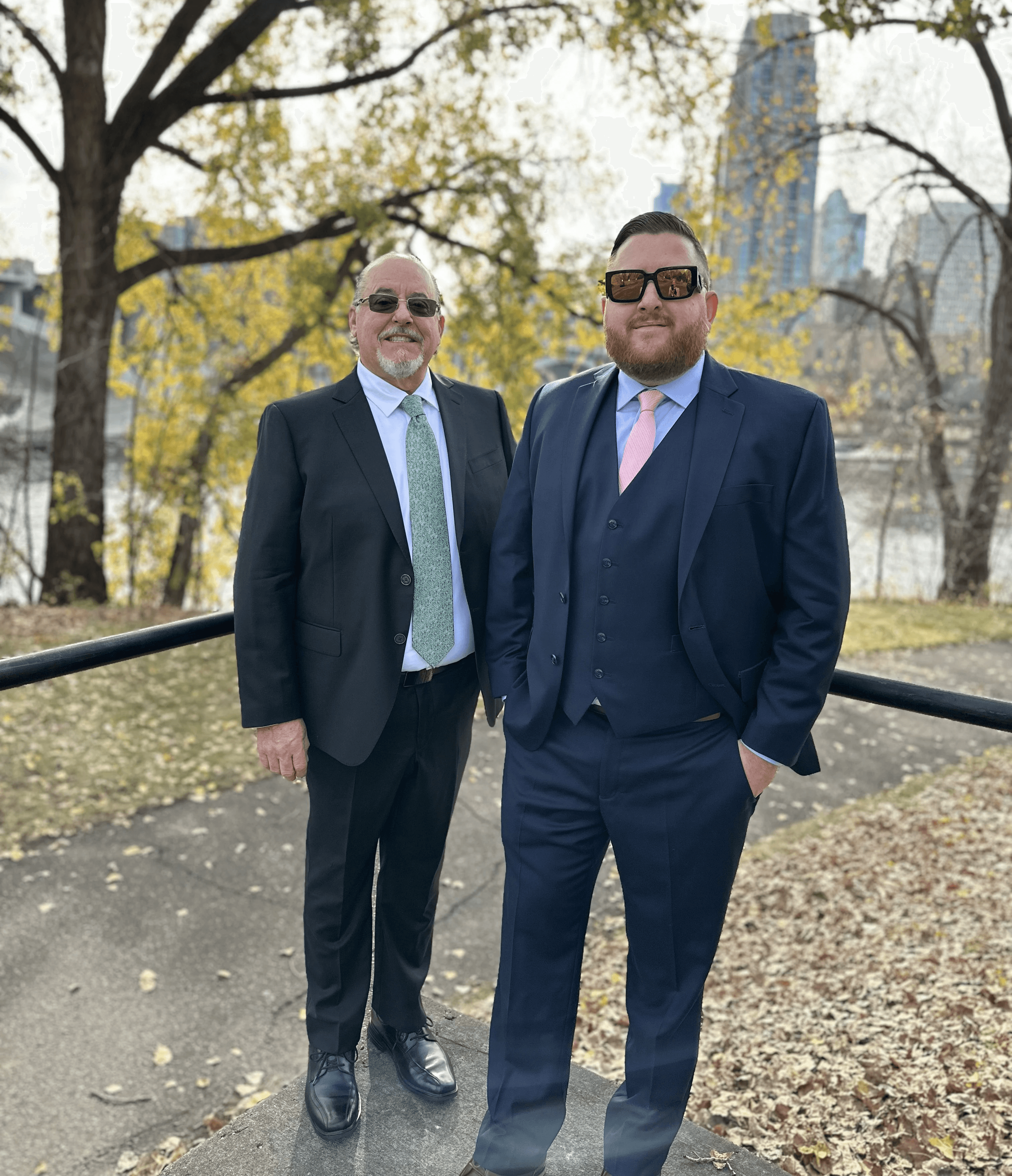 Group of people gathered around a wooden table with laptops, shaking hands during a team meeting.