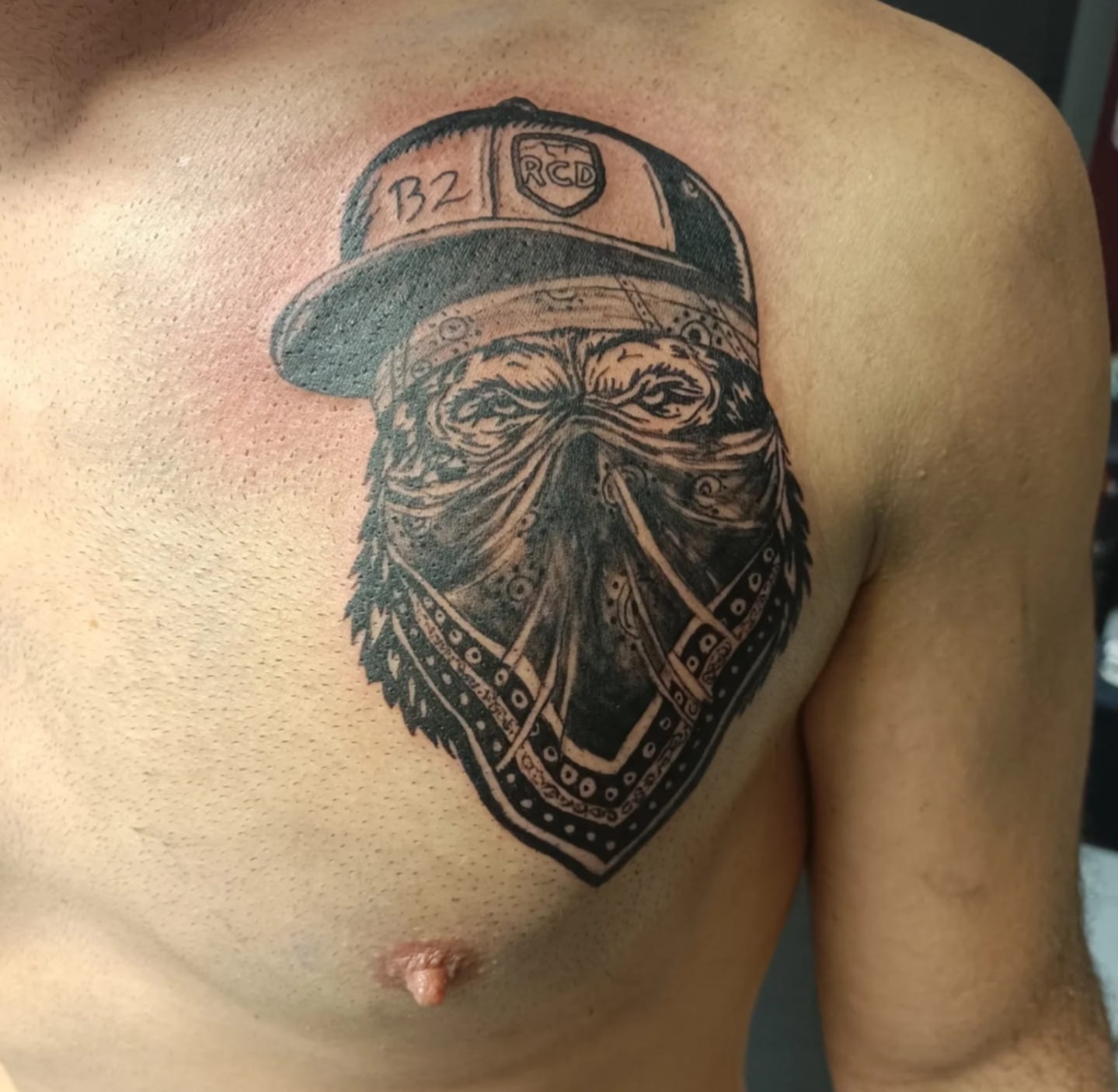 tatouage chimpanzé avec une casquette sur le torse d'un homme