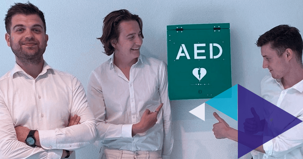 Drie mannen bij een AED-kast