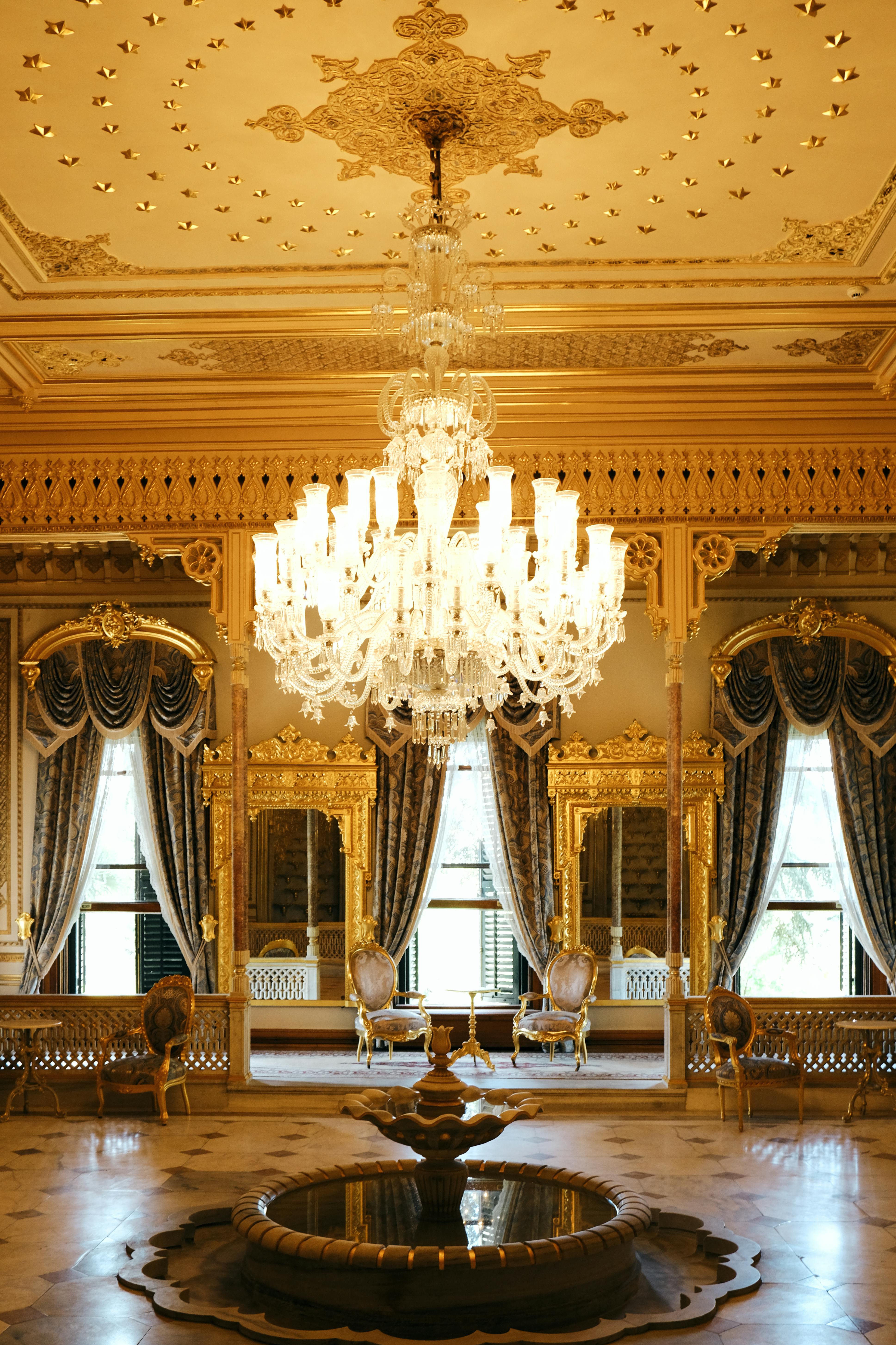 A dining table in an open dining area with traditional decorative art pieces displayed on the wall behind.