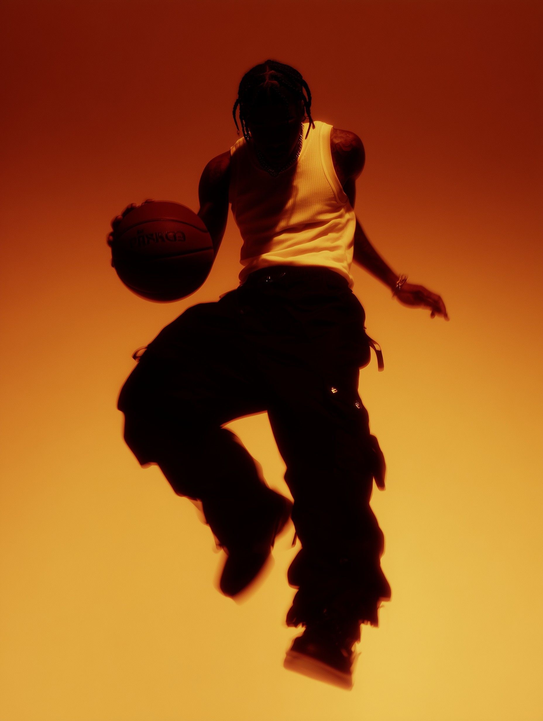 Basketball player jumping against warm orange gradient