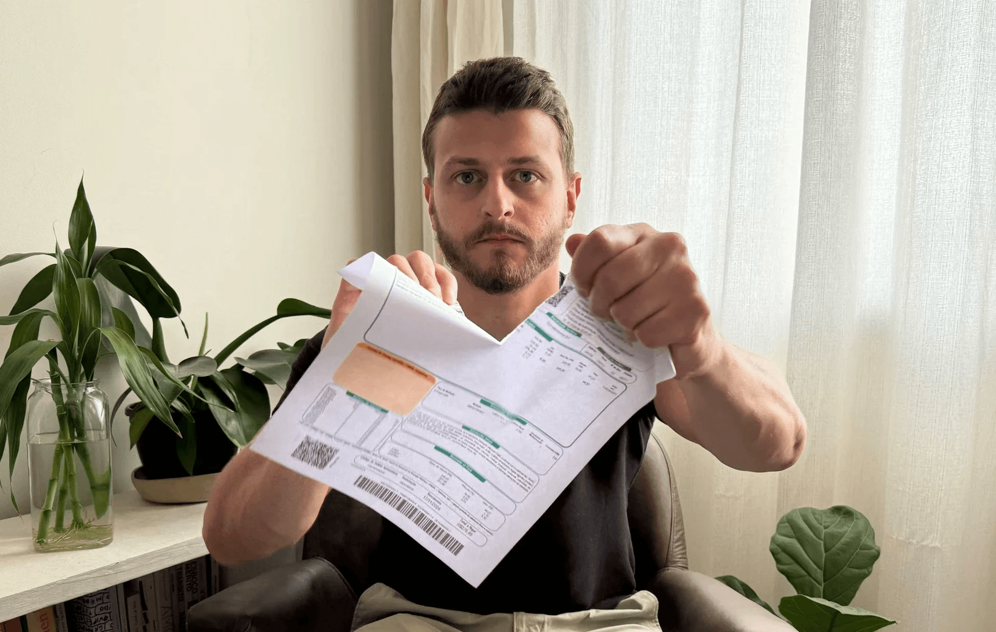 Homem rasgando papel da conta de luz