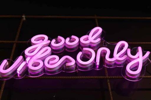 Pinkfarbenes Neon-Schild mit der Aufschrift „Good vibes only“ an einer dekorativen Wand im kAlps.
