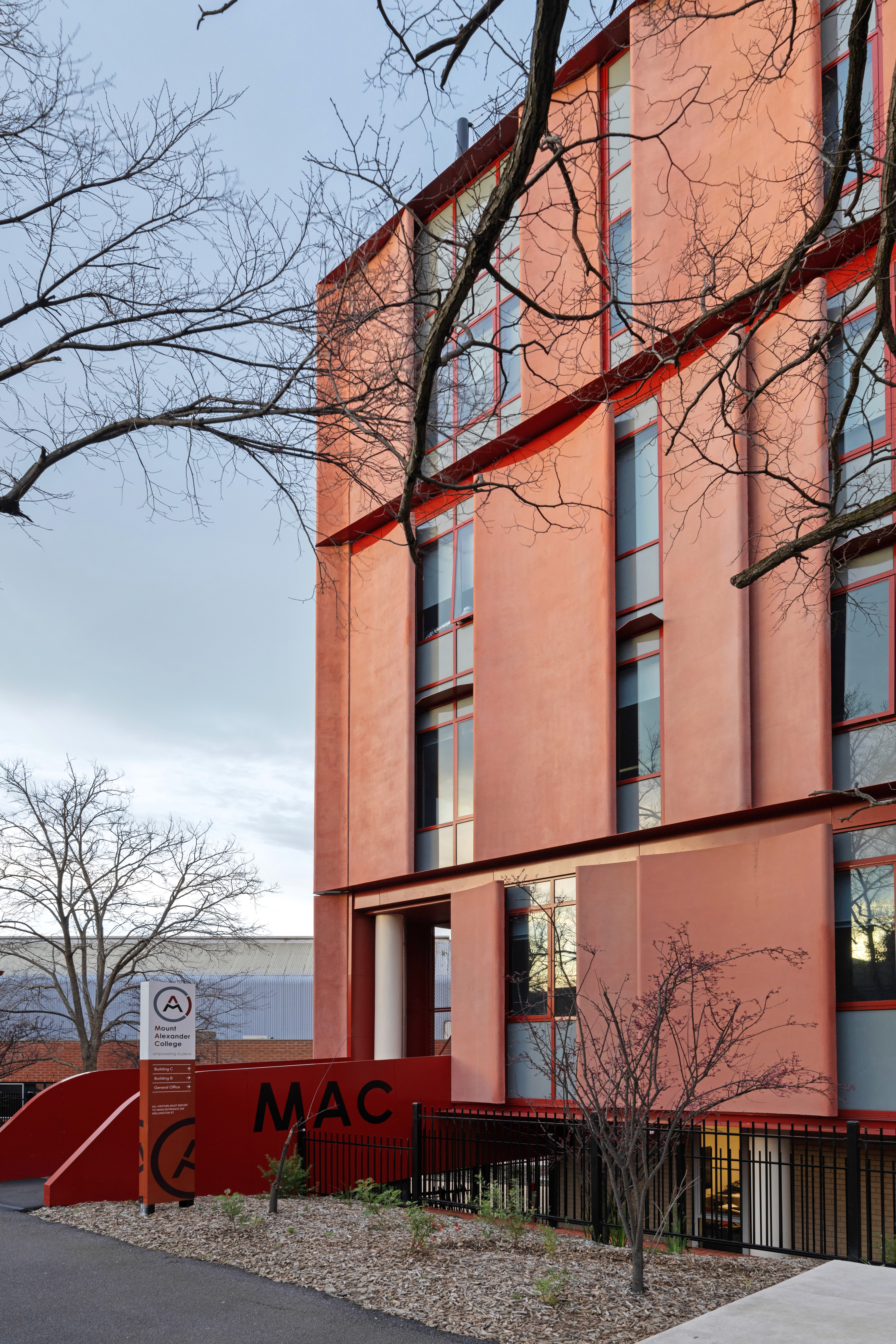 Modern swimming pool with lush green plants and flowers.