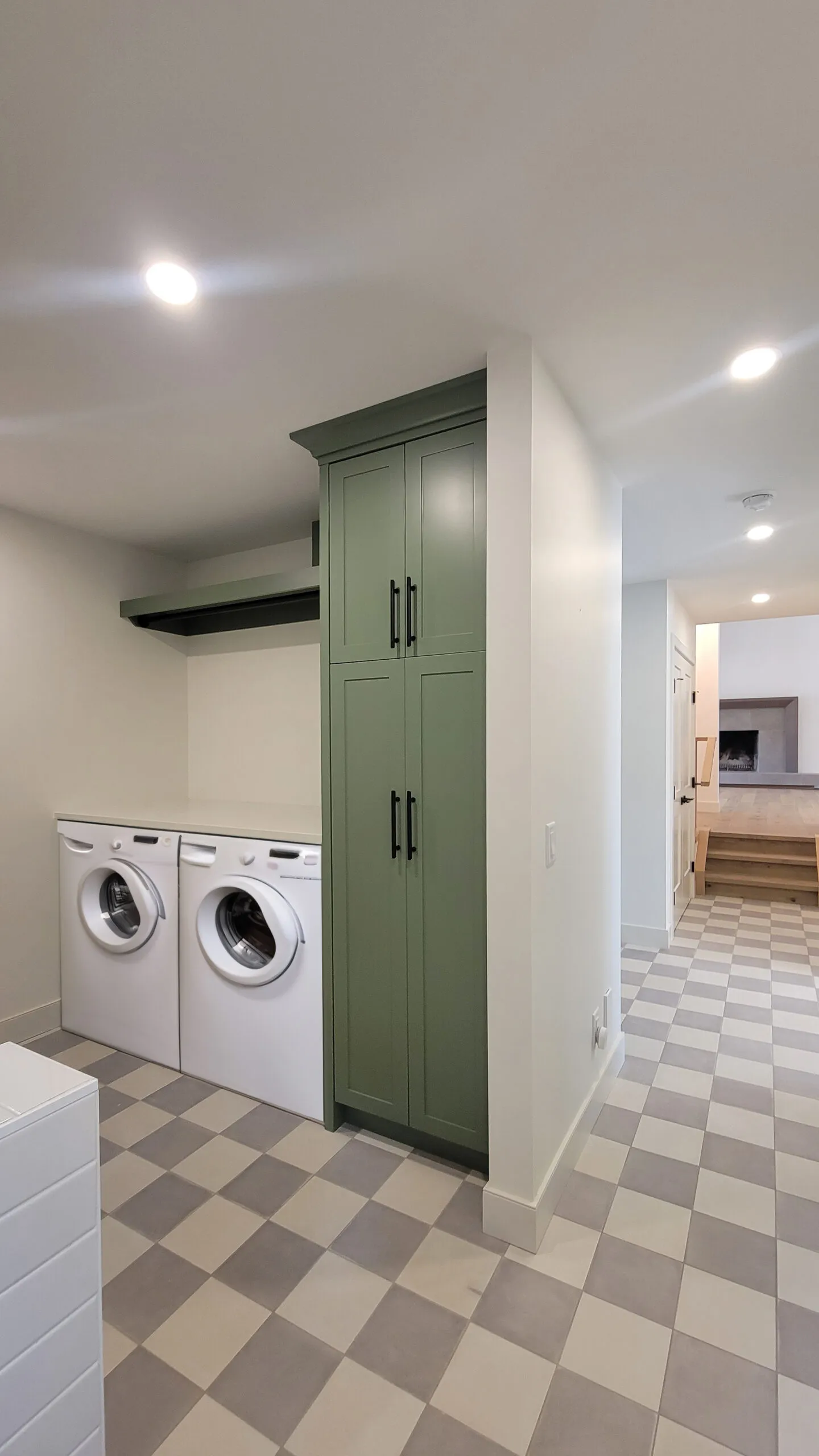Image of laundry room with green millwork, and machines.