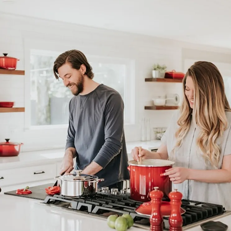 Couple cooking together in a bright kitchen