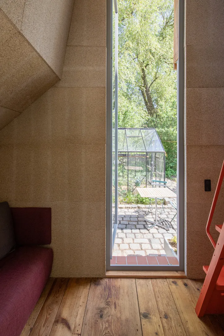 Finished room lined with hemp drywall panels, looking out to a garden
