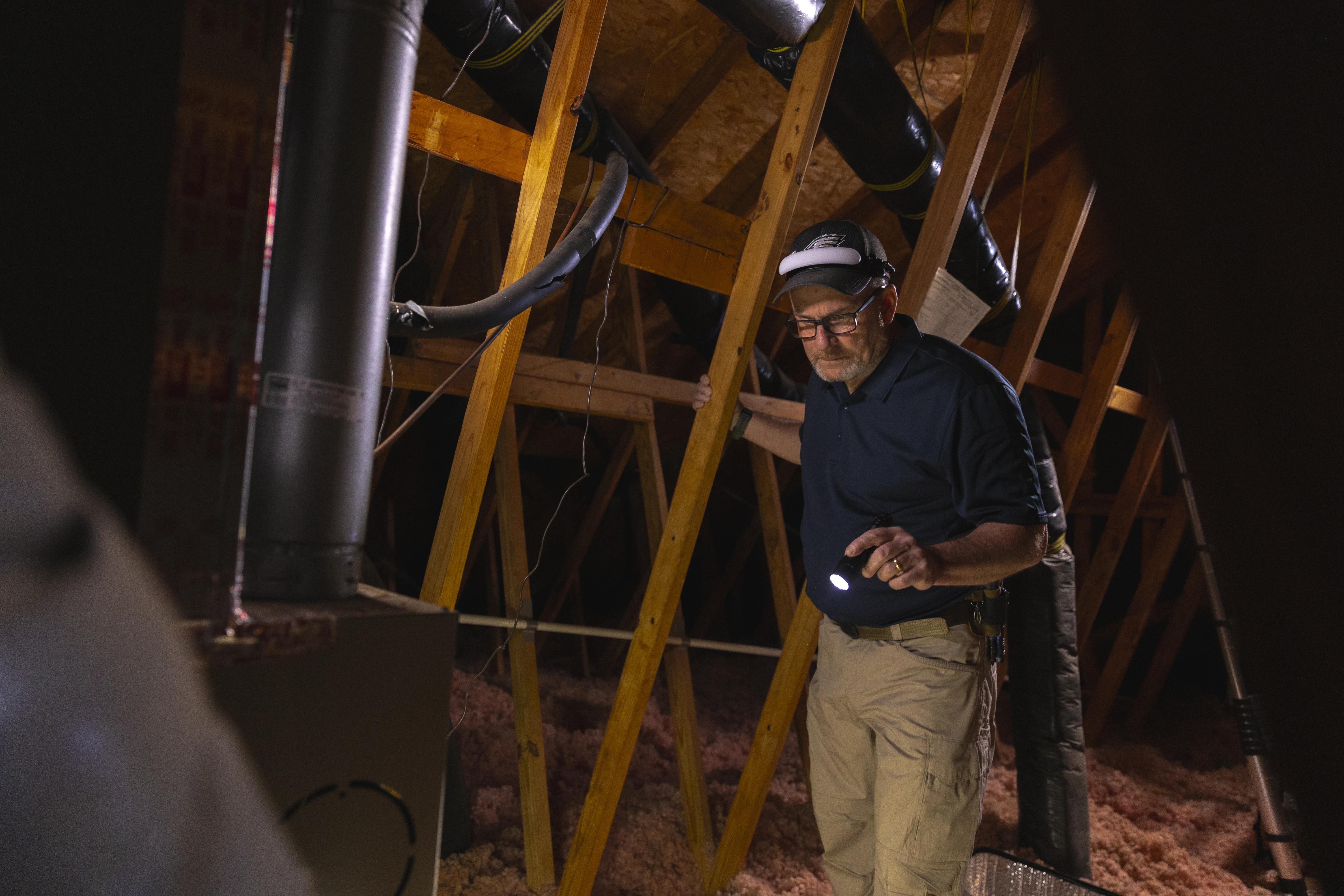 Brian Thomas inspecting an attic
