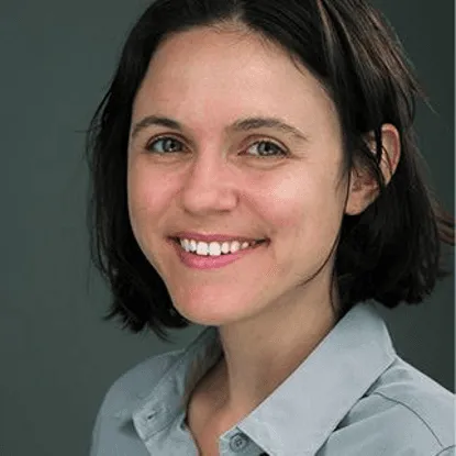 Close-up portrait of a smiling woman with short, dark hair, looking at the camera.