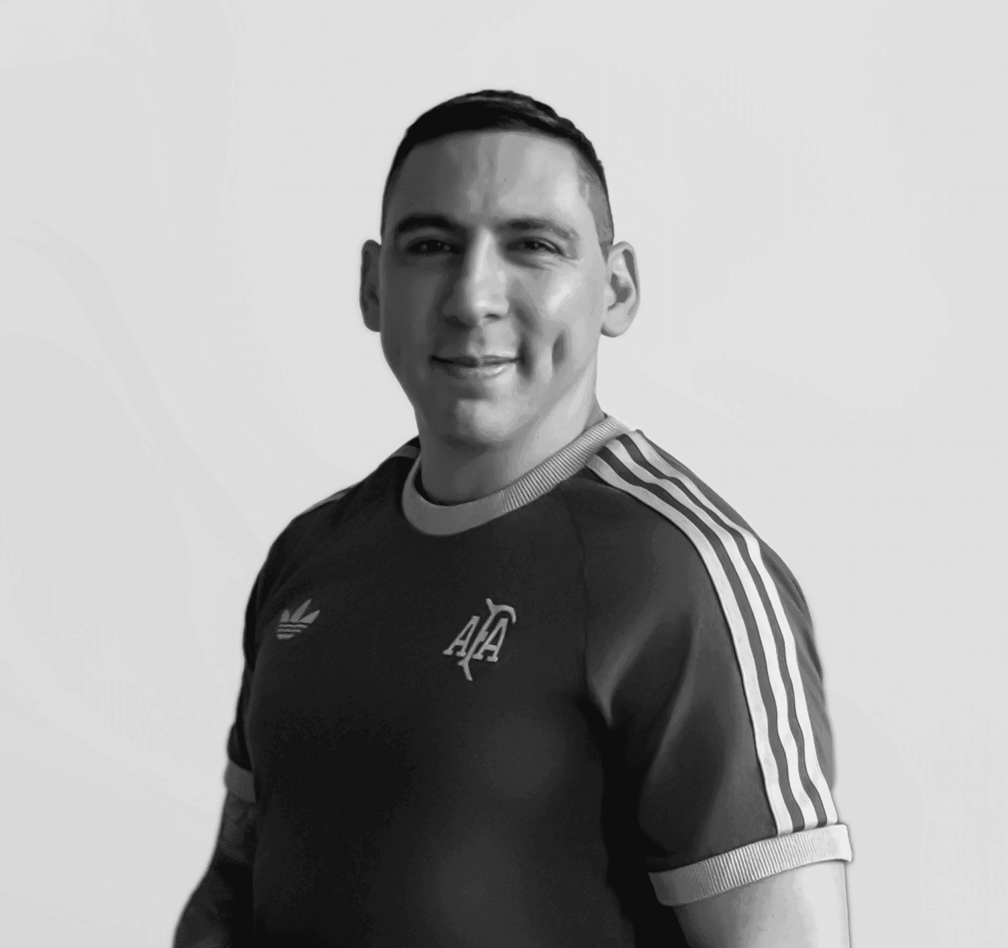 A thoughtful young person with dark hair gazes to the side, captured in soft black and white lighting.