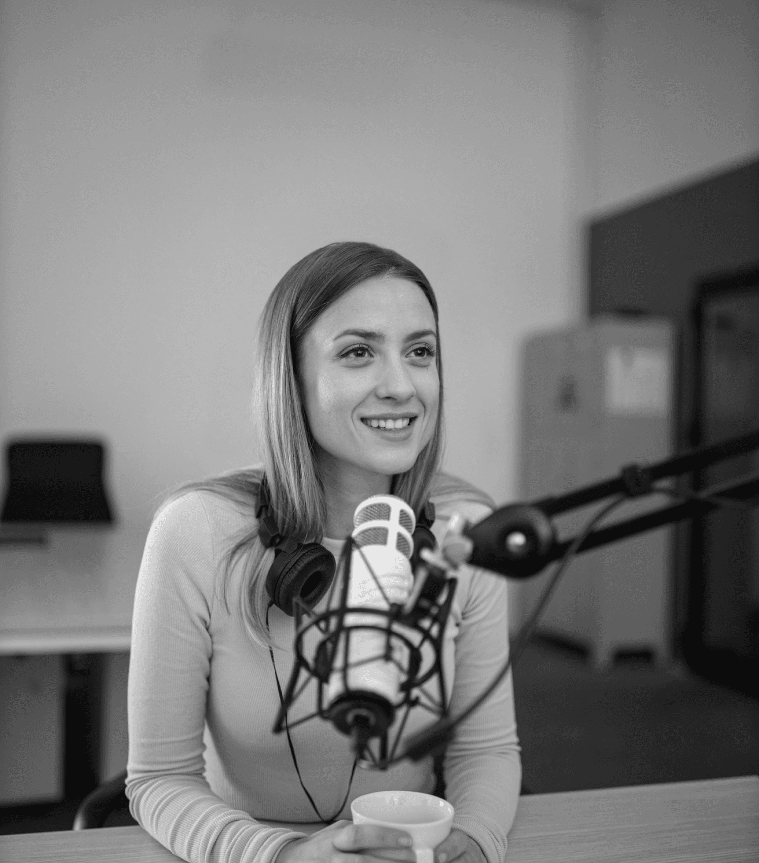 A woman hosting a podcast in a studio.