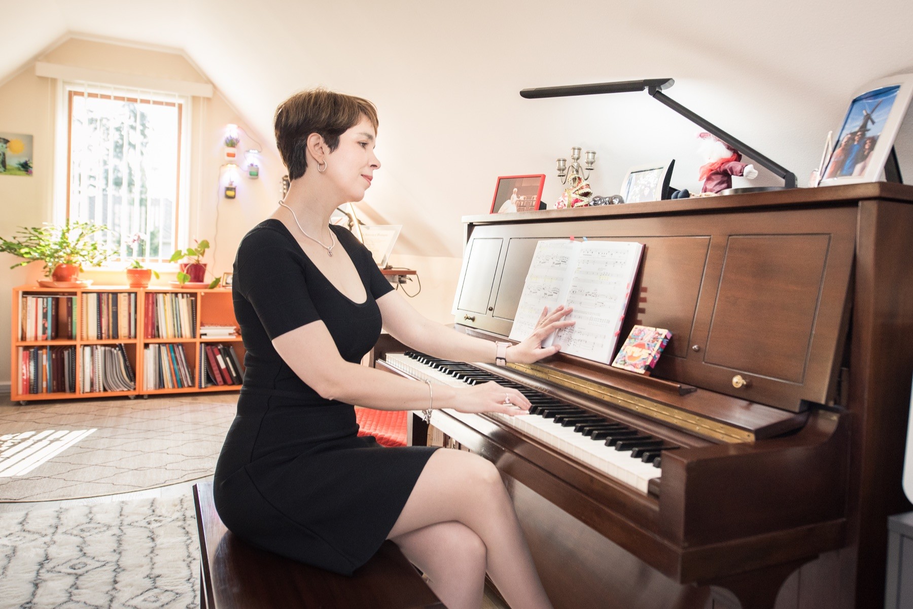 Dr. Raluca Marinescu seated at an upright piano
