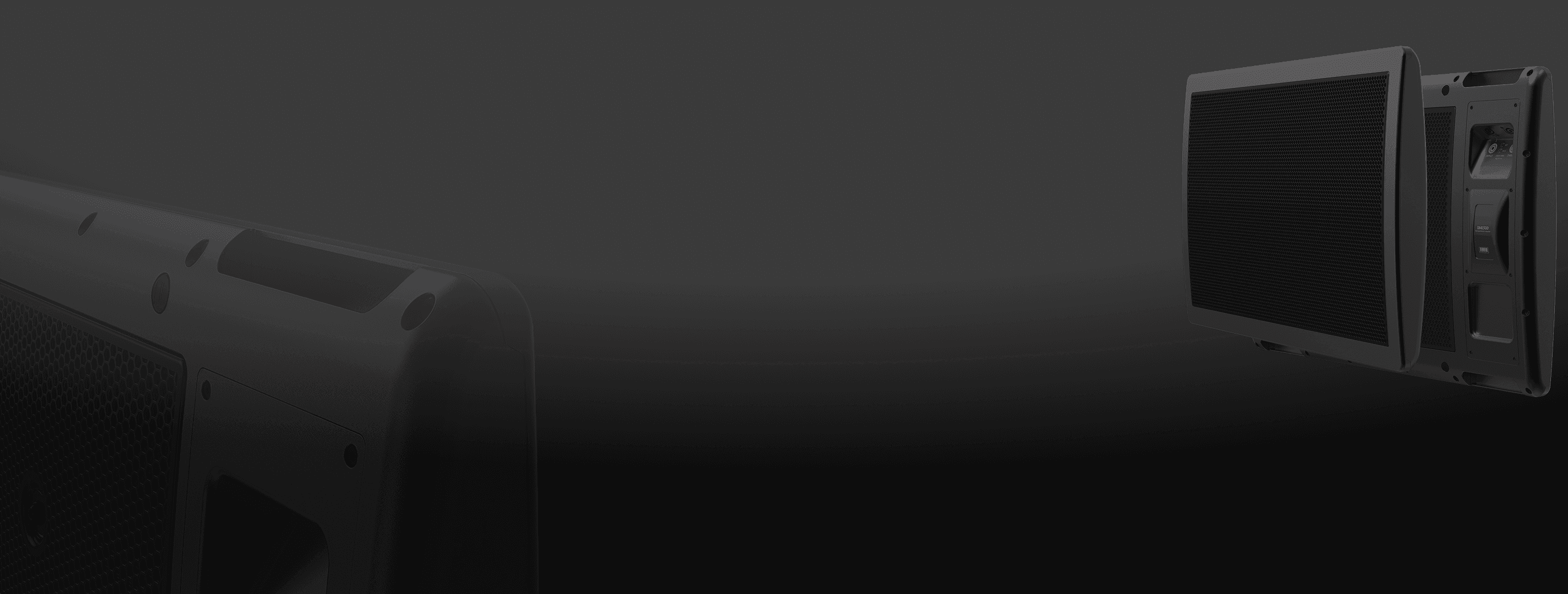 Black speakers and audio equipment on dark background.