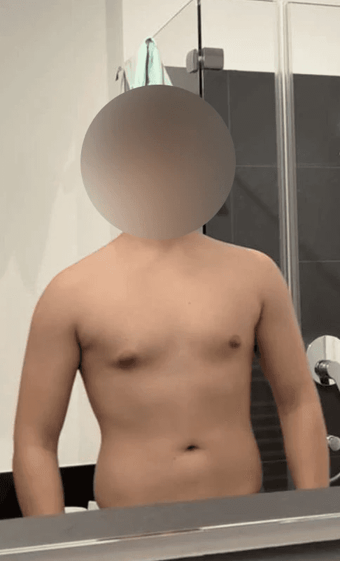 greyscale photo of woman in bralette inside room